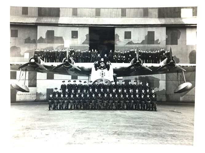 Large aeroplane with men in front and on wings.