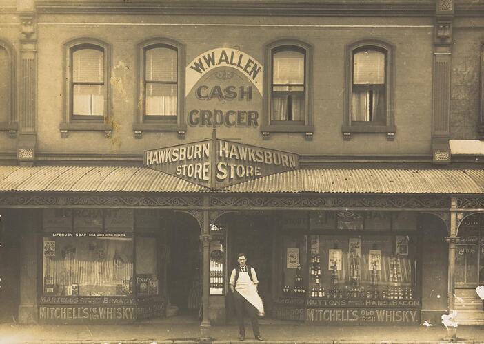 Digital Photograph - Owner Standing outside WW Allan's Grocers, Hawksburn, 1920