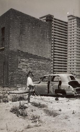 Digital Photograph - Girl playing with Stick, in front of Demolished House, between Rathdowne & Lygon Streets, Carlton, 1968