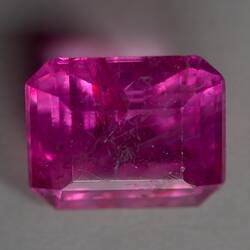 Pink, cut, rectangular gem.