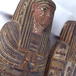 Egyptian coffin, base and lid decorated with colourful pictures. Face detail.