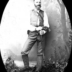Bearded man holding a rifle.
