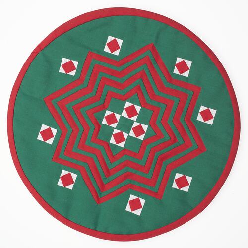 Circule turquoise fabric with red and white patterns.