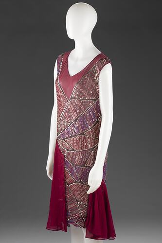 Sleeveless, patterned, and predominantly crimson dress with sequins.