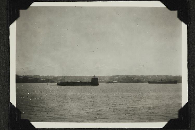 Water with submarine and land in background.