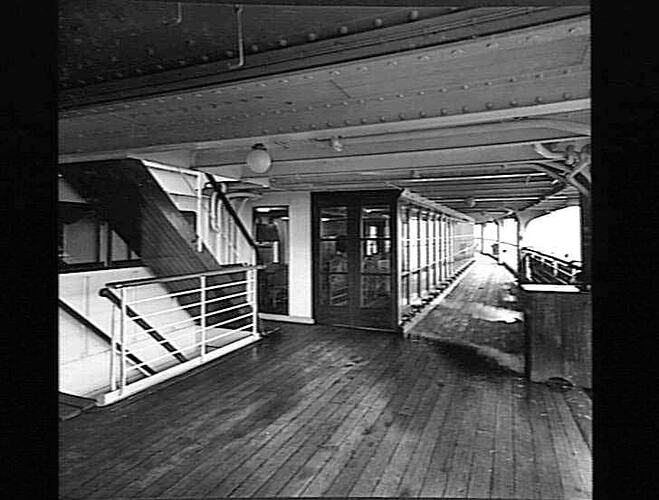 Ship exterior. Stairs at left and glass doors leading to interior in centre.
