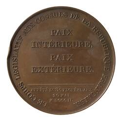 Round medal with raised text.