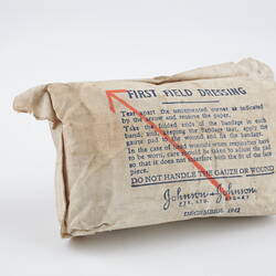 Package printed with text, with diagonal red line, containing bandage