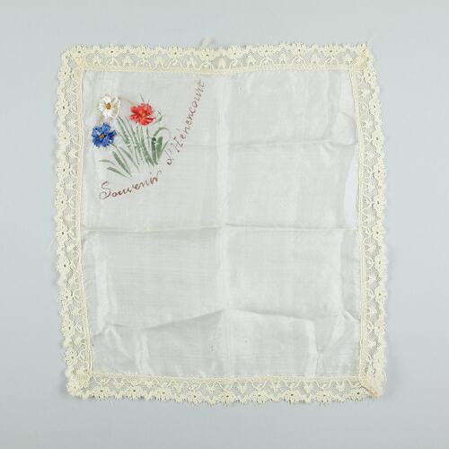 Square white cloth with embroidered flowers at top left.