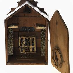 Wooden cuckoo clock, back view. Door open showing mechanism.