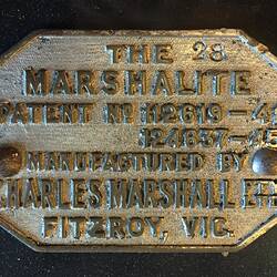 Octagonal metal plate with stamped text.