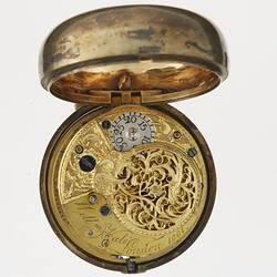 Pocket watch within gilt and tortoise shell case. Open to expose decorative and engraved mechanism.