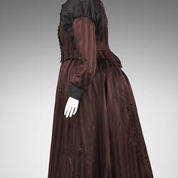 Burgundy and black satin striped dress. Fitted bodice, long sleeves, black buttons and billowed shoulders. Pro