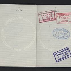 Open passport with two white pages with printed pattern. Multiple stamps.