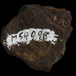 Orange brown rock, black numbers written on white streak.