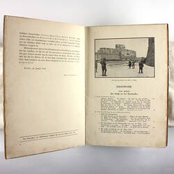 Inside pages of book showing photo of ancient building and text.