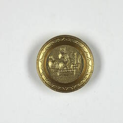 Front of gold round toy plate.