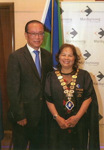 Man and woman in formal attire with woman wearing mayoral regalia.