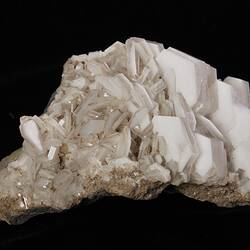 Pale pink mineral with pointy crystals.