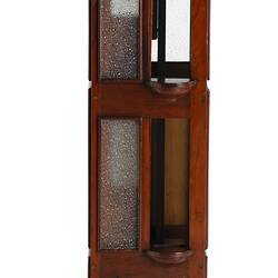 Wooden passenger lift model with 3 floors, each with opaque glass windows and sliding door. Handle at top left