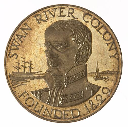 Round bronze-coloured medal with bust of naval man facing left. Sailing ships in background. Text around edge.