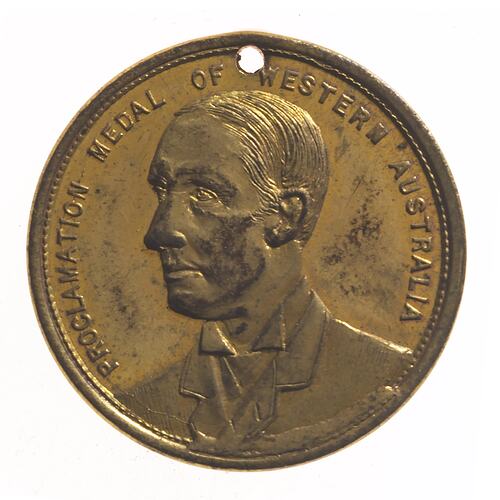 Round bronze-coloured medal with bust of man facing left. Text around edge and hole punched at top.