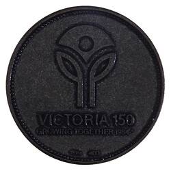 Round medal with logo of two single leaf stems supporting central inverted triangle. Text below.