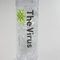 Clear cylinder with clear puzzle pieces inside.