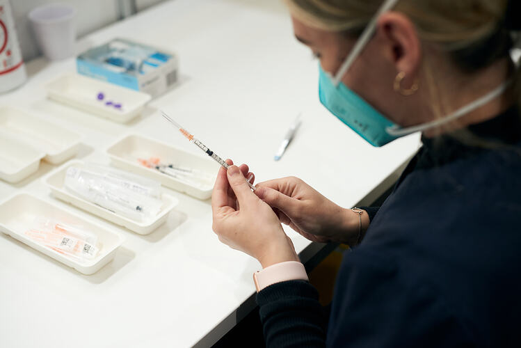 Pharmacist checking syringe of COVID-19 vaccine, St Vincent's Vaccination Hub, Melbourne Museum, 23 Sep 2021