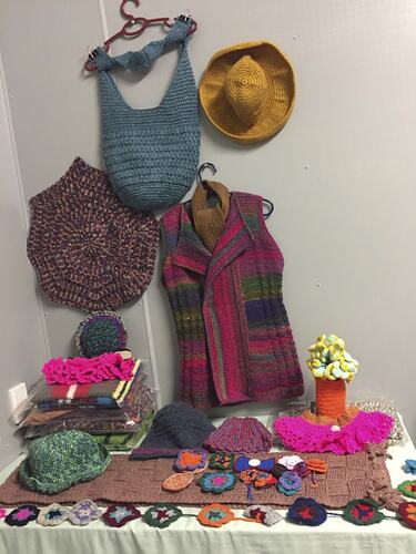 Display of crochet crafts including a bag and hat.