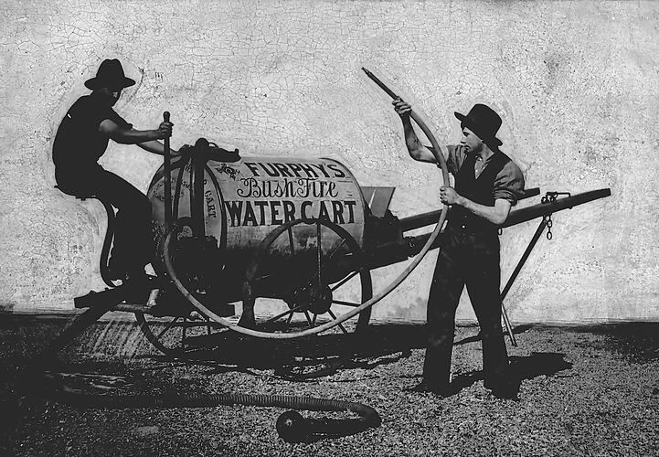 [Two men demonstrating the Furphy's water cart, used for fighting bushfires, Shepparton, 1900.]