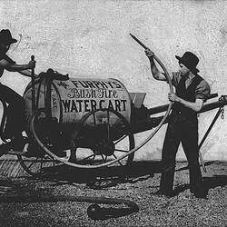 Negative - Men demonstrating the Furphy's water cart, used for fighting bushfires, Shepparton, 1900.