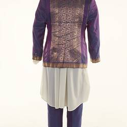 Purple sari two-piece suit and matching tie, long off-white shirt. Gold detail on jacket edging. Back view.