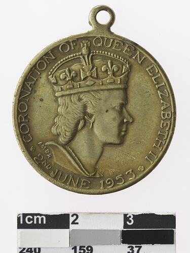 Round medal with profile of a crowned woman, text surrounding.