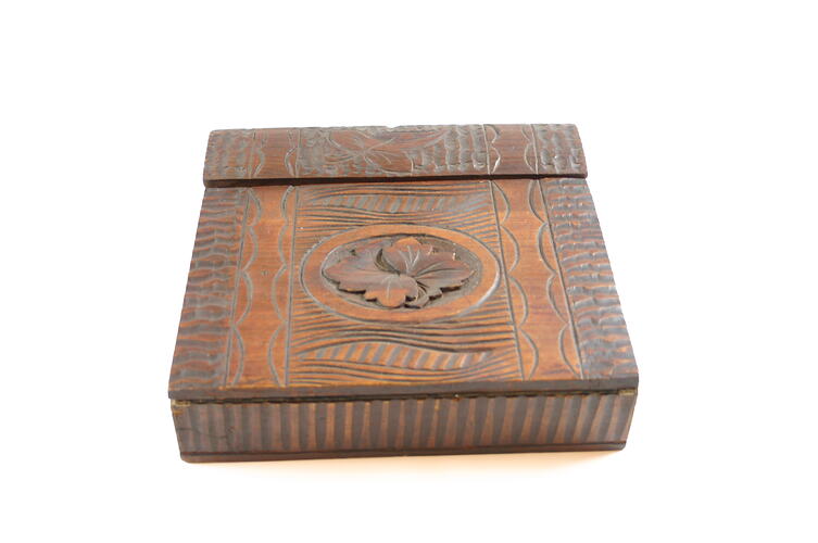 A wooden writing desk with a floral design.