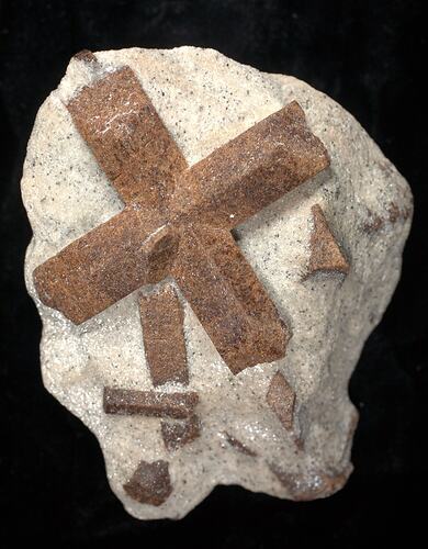 Blocky crystals crossing on a cream-coloured rock.