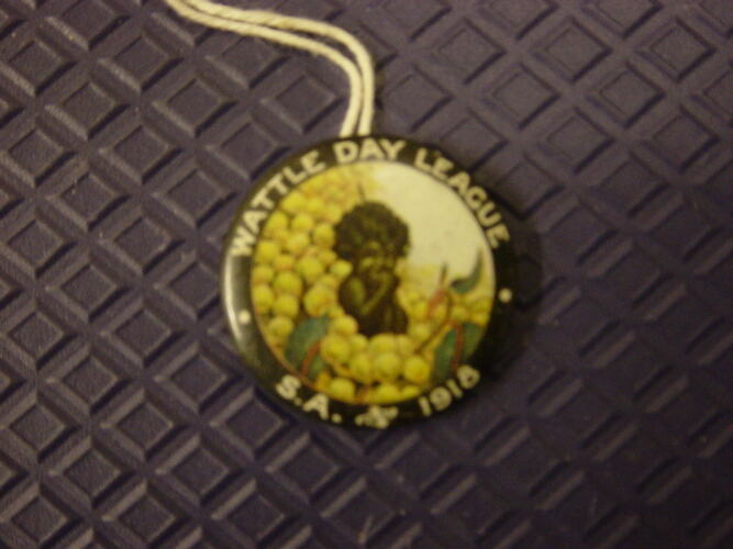 Badge with yellow flower and black child.
