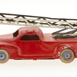 Red toy truck with roof ladder, left view.