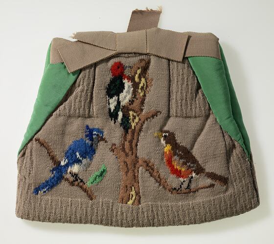 Tea cosy decorated with three birds on branches.