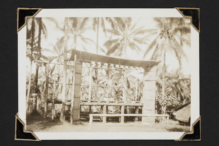 Partially constructed outdoor stage with palm trees behind.