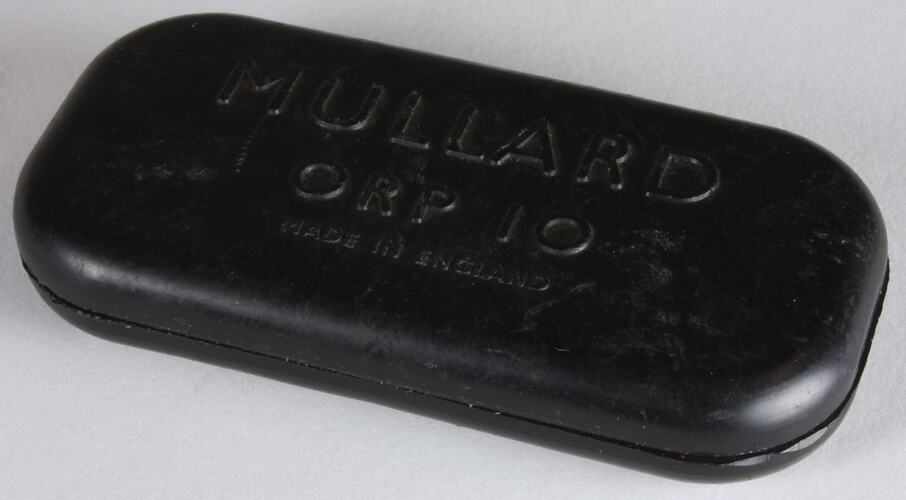 Rectangular dark photocell. Raised lettering on top.