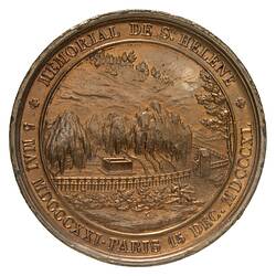 Round bronze medal with rural scene and raised text around edge.