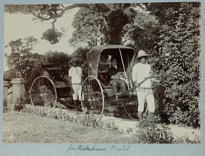 Two rickshaws and drivers, one carrying passenger.