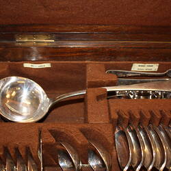 Open wooden cutlery box. Detail of soup ladle.