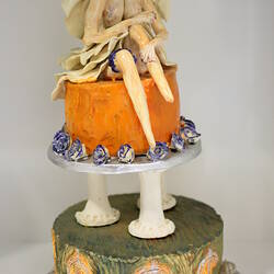 Upper tier of ceramic wedding cake with bride figure.