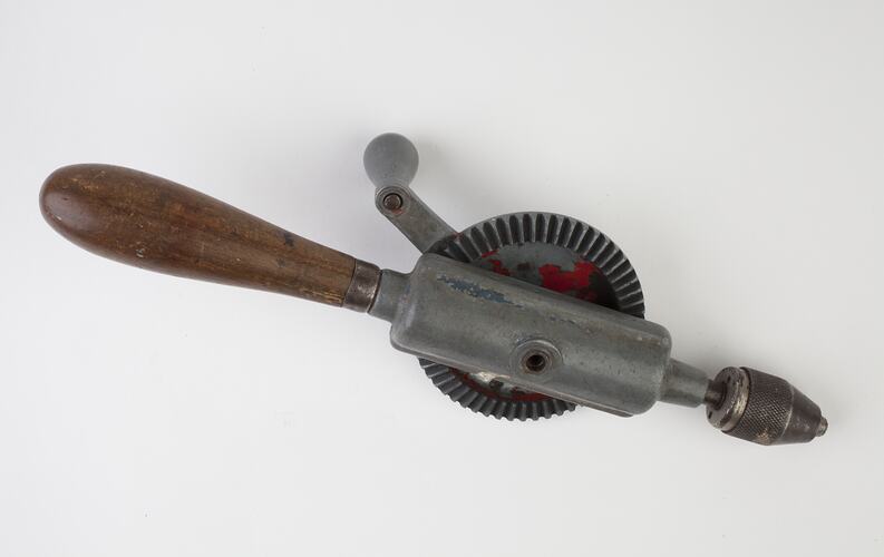 Metal hand turning drill with wood handle.
