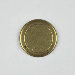 Back of gold round toy plate.