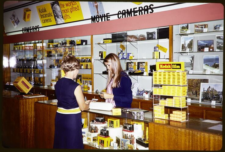 Two women at a retail counter.