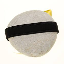Back of pale round grey river stone with black band.