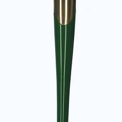 Titanium smooth, curved shard-like baton in dome-shaped stand. Gold at top and green mid sectoin down.